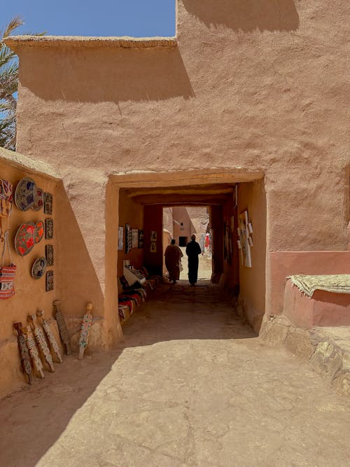 People Walking in Tunnel under Building