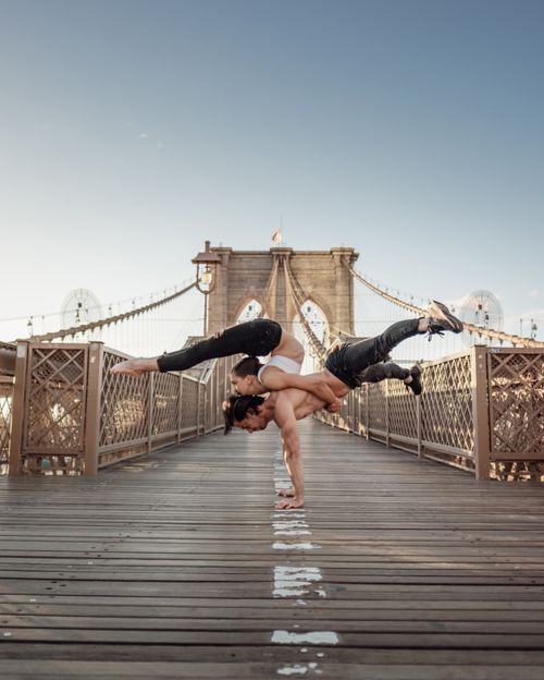 Free Two performers showcase acrobatics on Brooklyn Bridge against a clear sky. Stock Photo