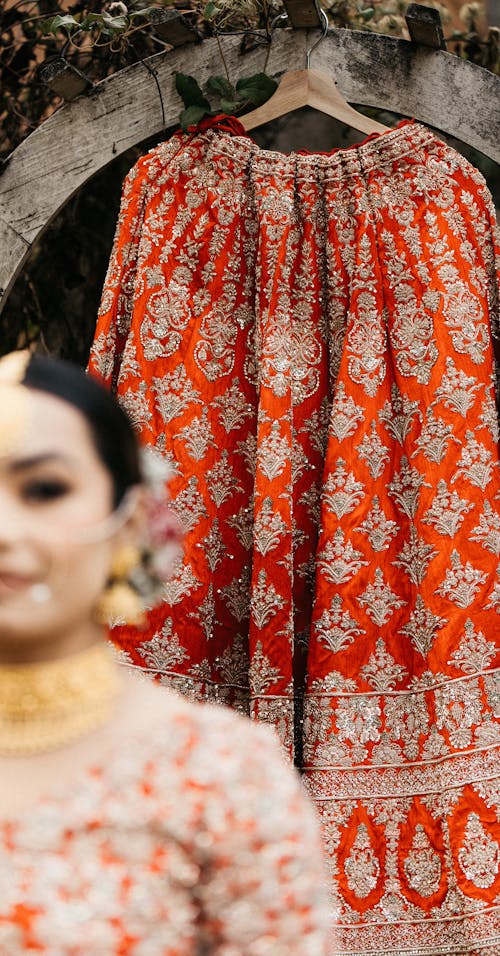 Traditional Clothing on Hanger behind Woman