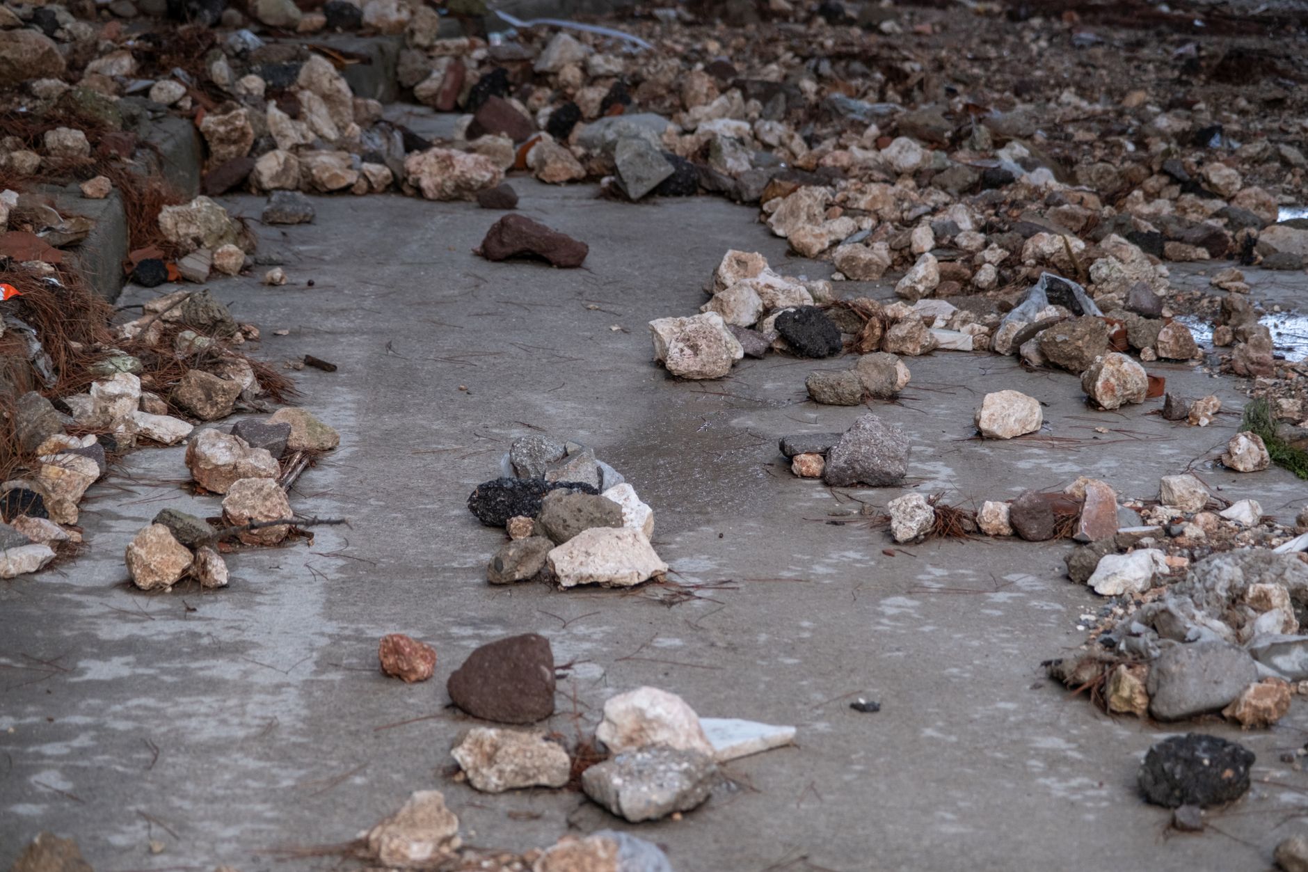 A collection of scattered rocks and pebbles on a concrete surface in İzmir, Türkiye.