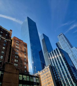 Low angle view of modern skyscrapers in New York City with clear blue skies.