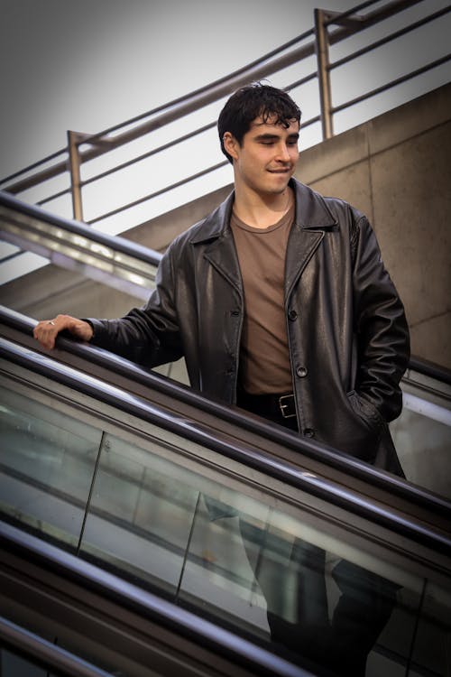Young Man in a Leather Jacket on an Escalator