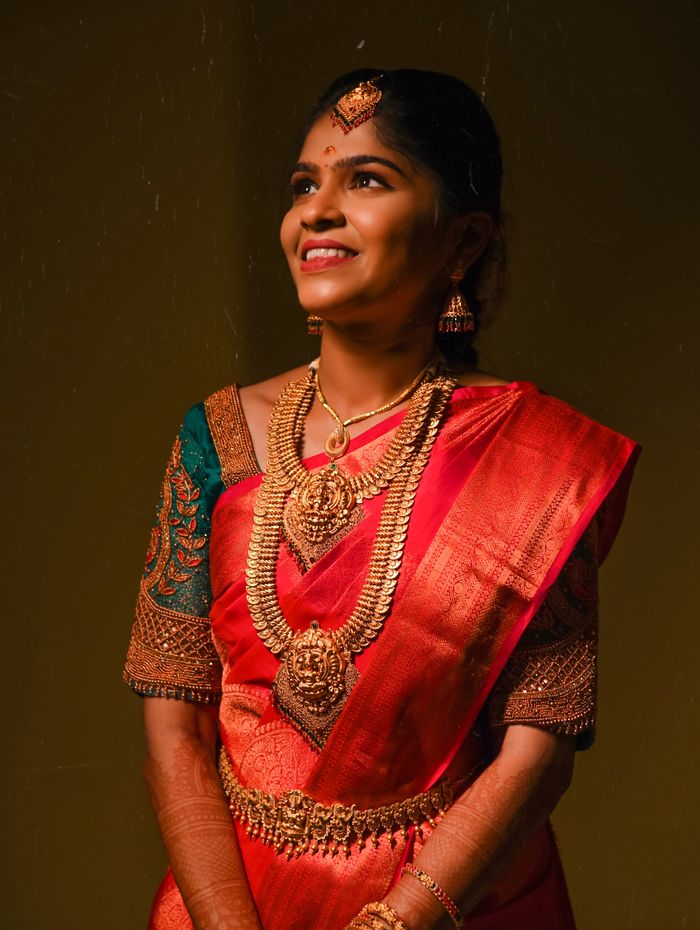 Tamil bride in red Kanchipuram silk saree with layered temple gold
