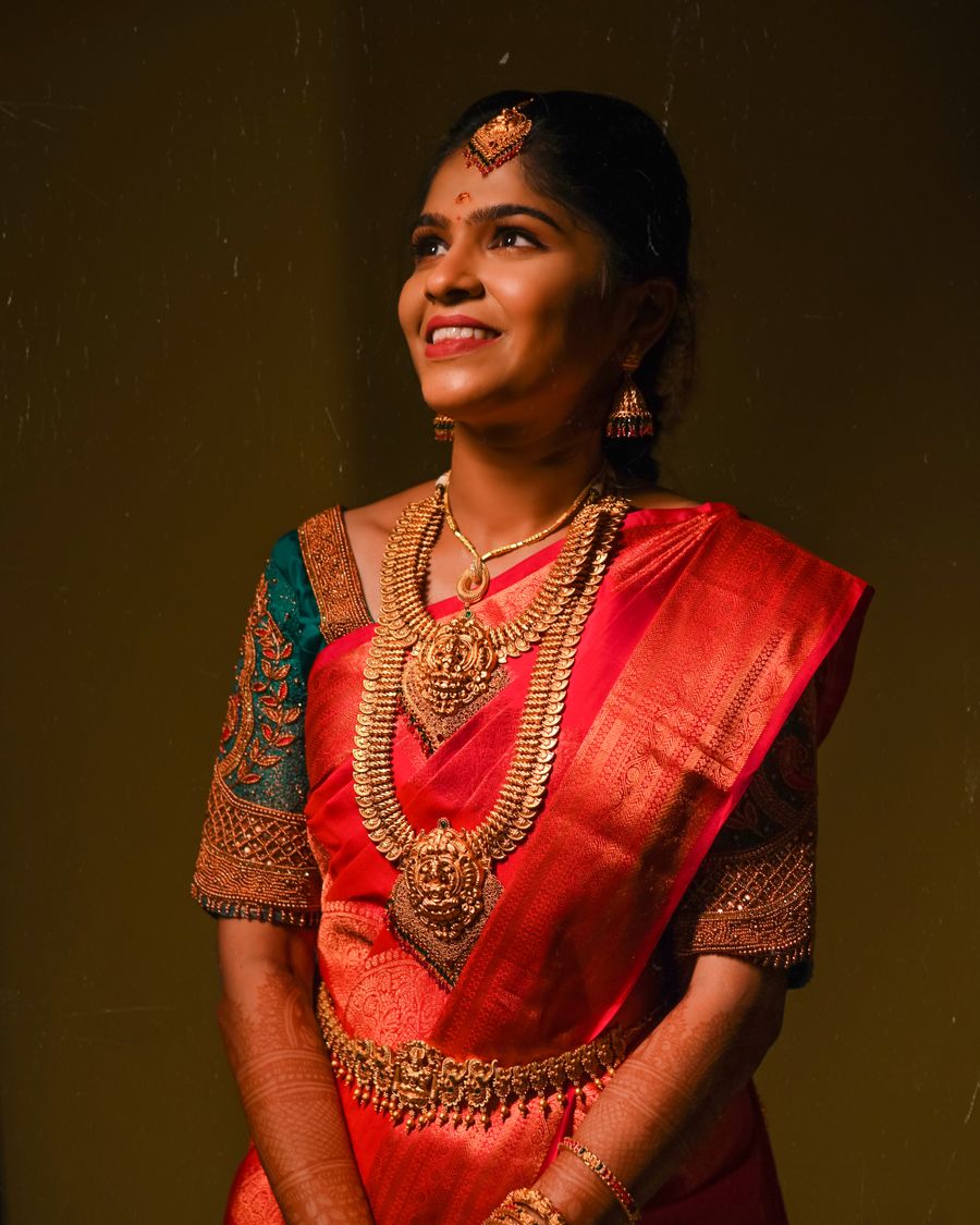 Tamil bride in red Kanchipuram silk saree with layered temple gold