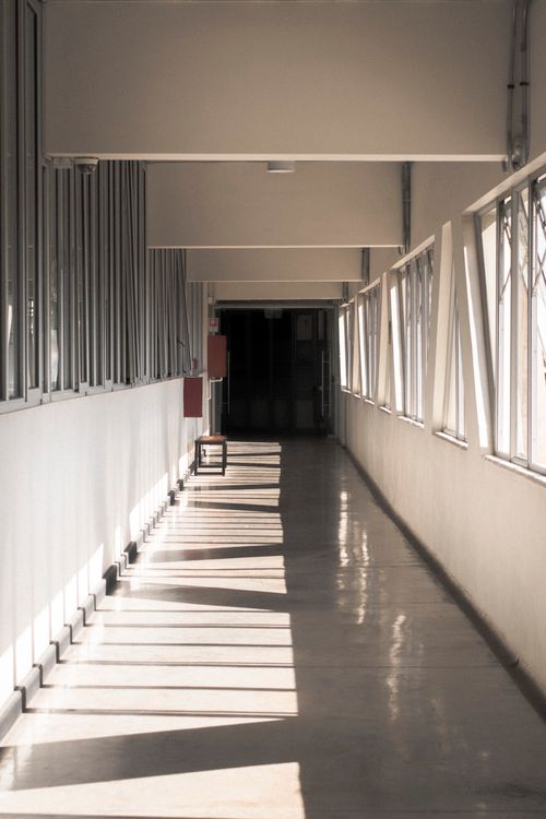 Free A sunlit corridor with open windows casting shadows, creating a serene interior atmosphere. Stock Photo