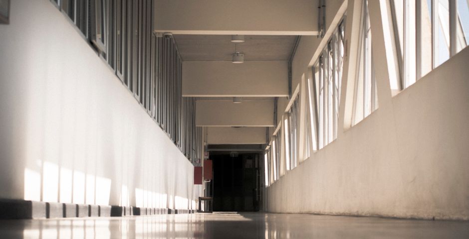 A long institutional corridor — the kind of common area a pest control specification has to name zone by zone