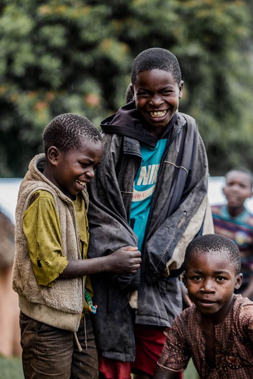 Free Three boys sharing a light-hearted moment outdoors, full of smiles and laughter. Stock Photo