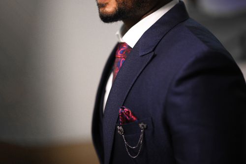 Free Close-up of a man in a navy suit with a stylish red tie and pocket square. Stock Photo