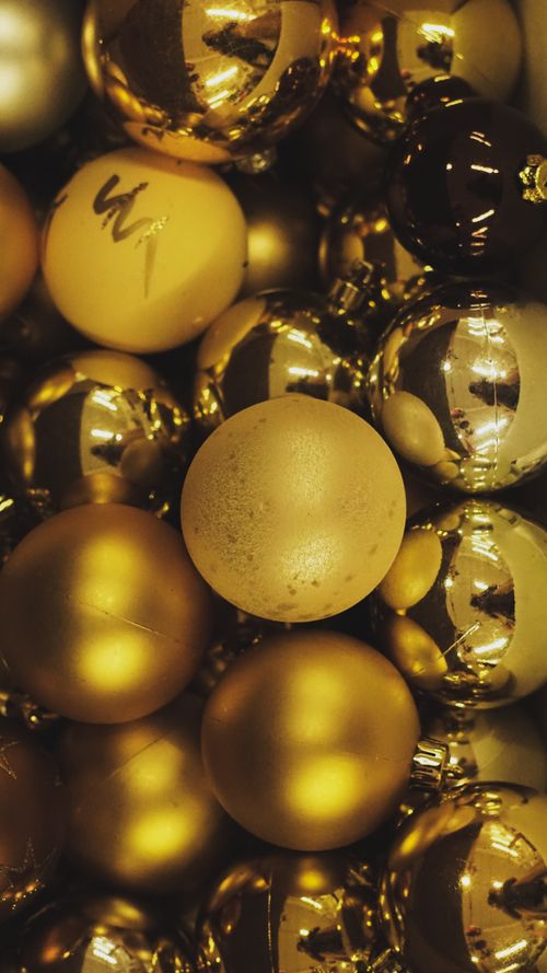 Free A warm, festive close-up of shimmering golden Christmas baubles. Stock Photo