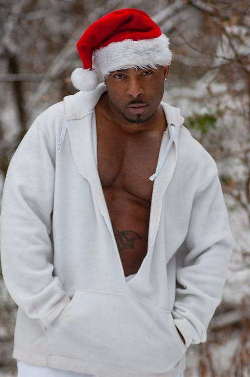 Man Posing in White Hooded Sweatshirt and Santa Claus Cap