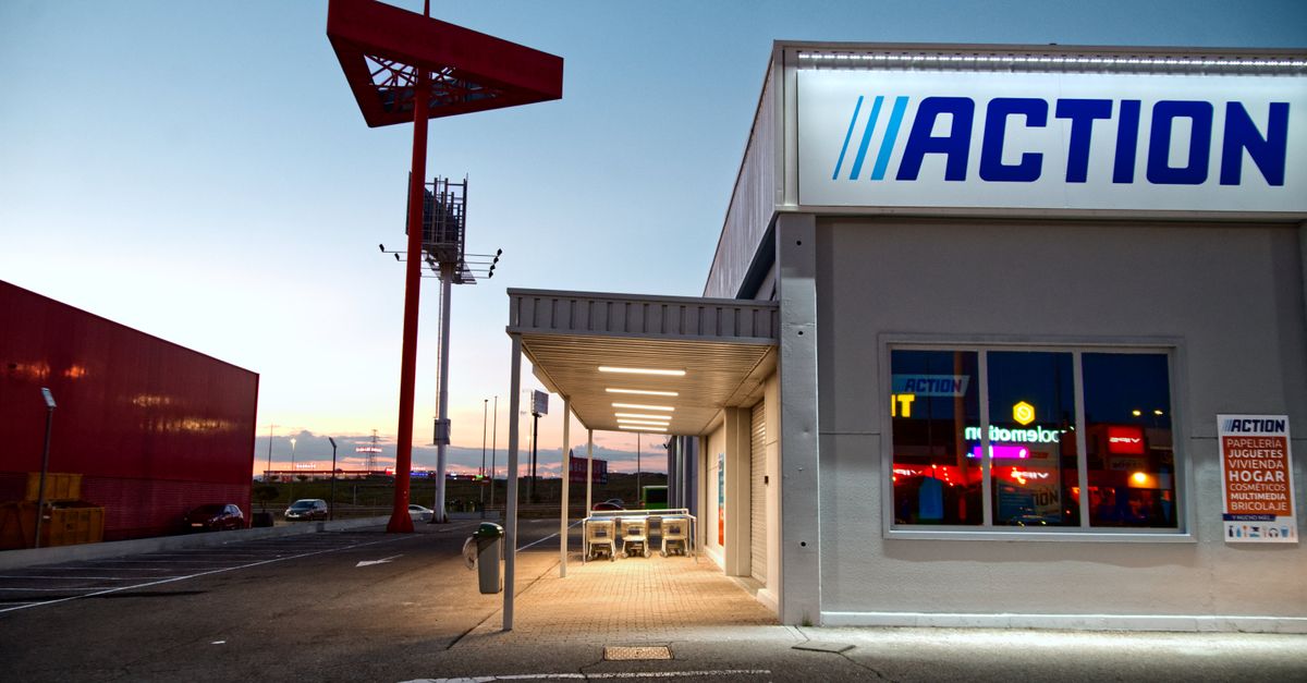 View of a commercial building with illuminated signage and empty parking during sunset.