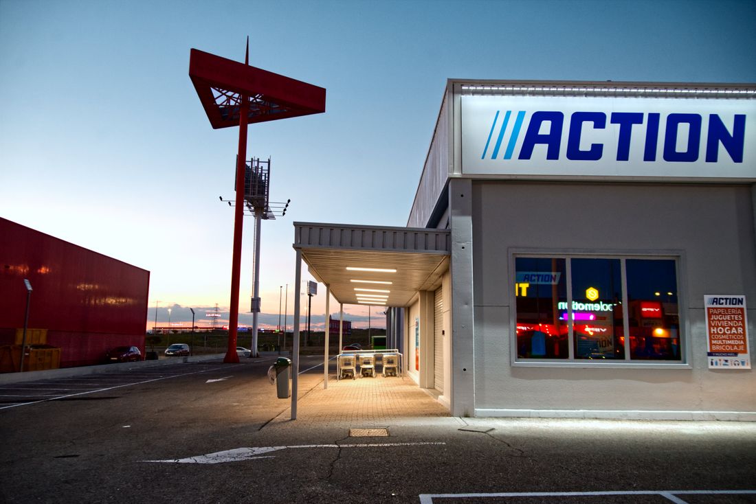 Retail store exterior with a parking area at a shopping plaza