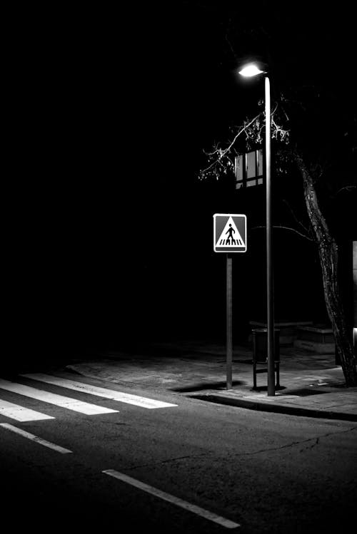 Black and White Photo of a Crosswalk on an Empty Street at Night