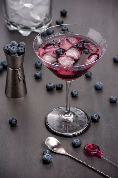 Free A close-up of a stylish blueberry martini cocktail in a martini glass with ice, perfect for a summer refreshment. Stock Photo