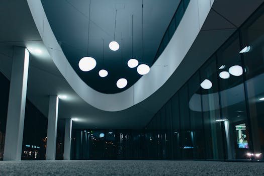 现代建筑内部，从低角度看去，可见照明的天花板灯和玻璃墙