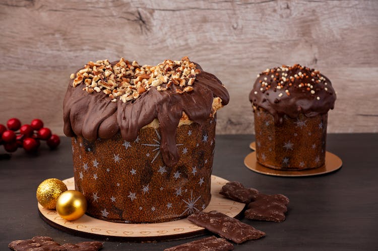 Christmas Cakes Covered In Chocolate And Topped With Crushed Walnuts And Sprinkles