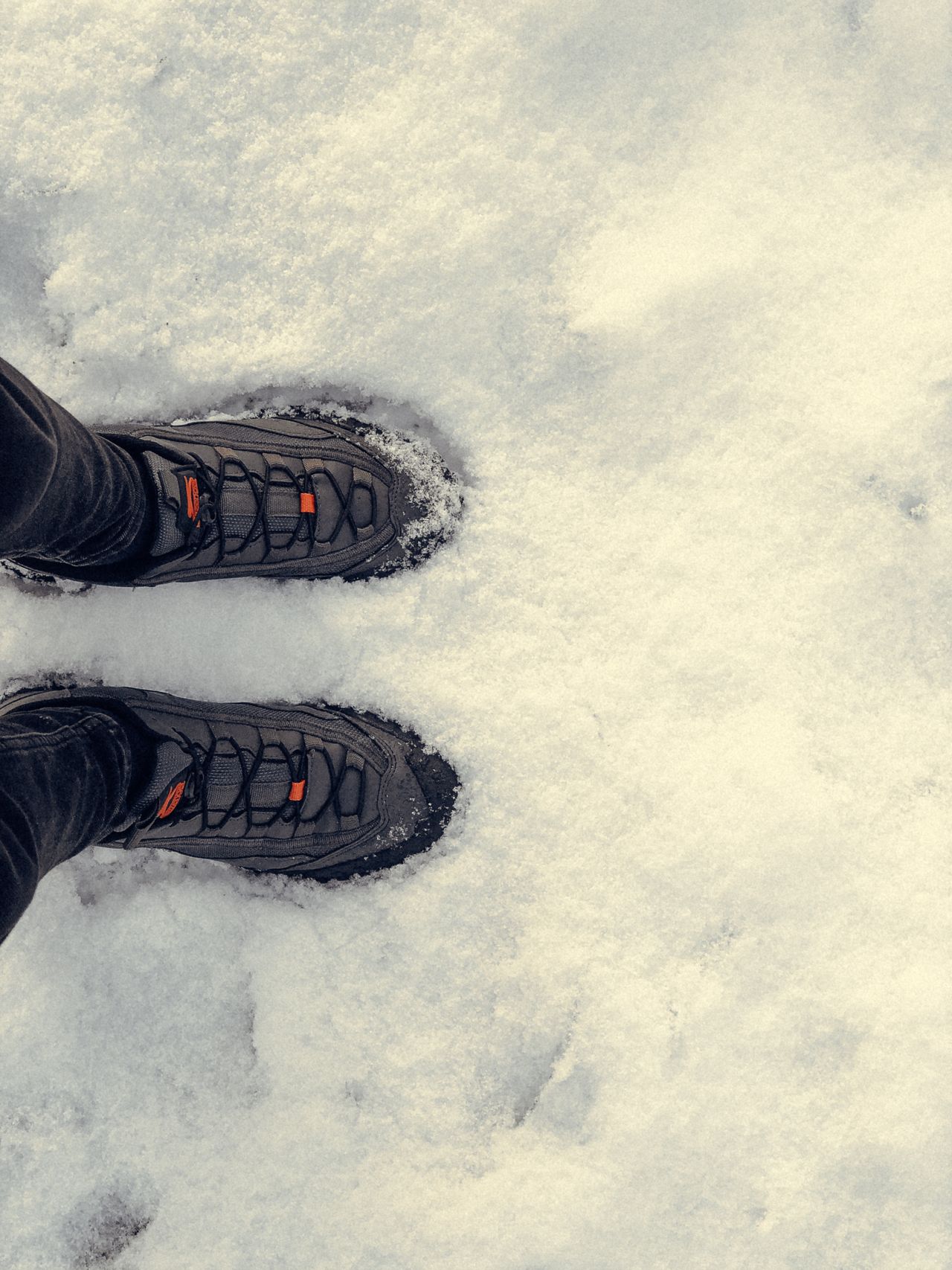 Dark winter boots standing on fresh snow