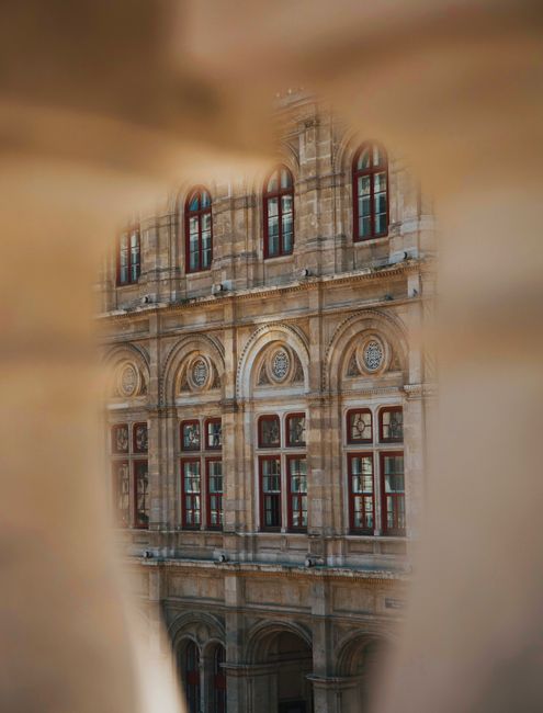 Detailed view of renaissance architectural facade through an archway, soft focus.