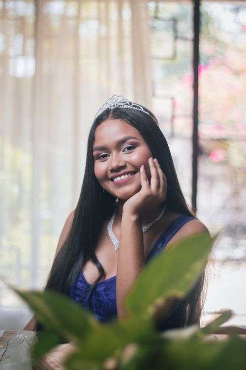 Free Portrait of a smiling woman with a tiara inside a well-lit room, showcasing elegance and fashion Stock Photo