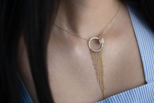 Close-up of a gold necklace featuring a butterfly pendant, perfect for fashion and jewelry collections.