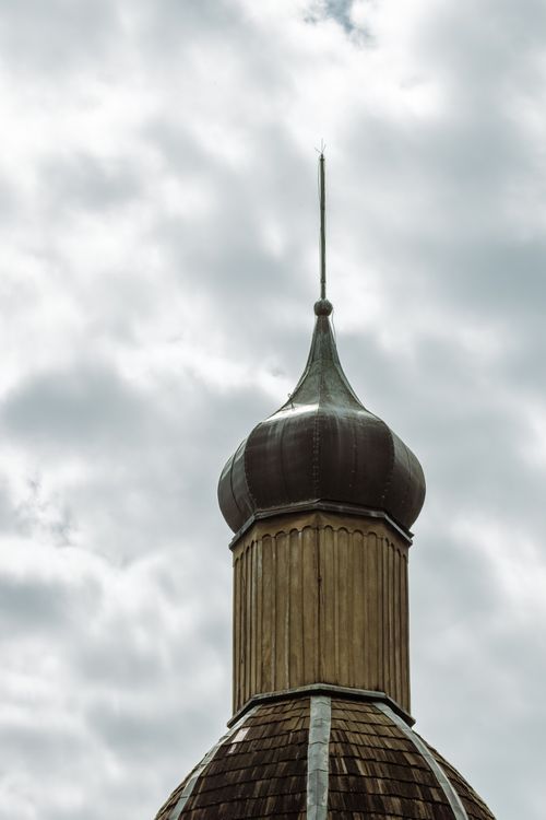 Free Close-up of a decorative building spire with a moody cloudy sky as the backdrop. Stock Photo