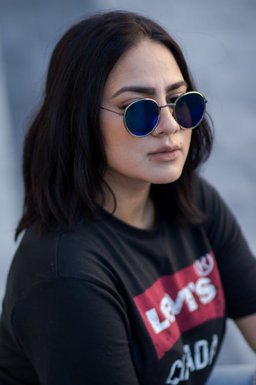 A woman wearing sunglasses and a t - shirt