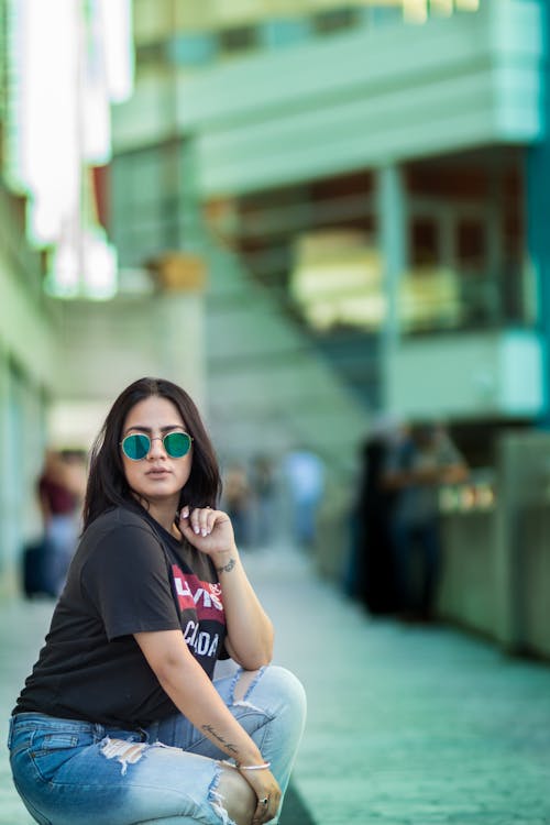 A woman in sunglasses sitting on the ground