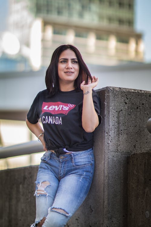 A woman in ripped jeans and a black shirt posing for a picture