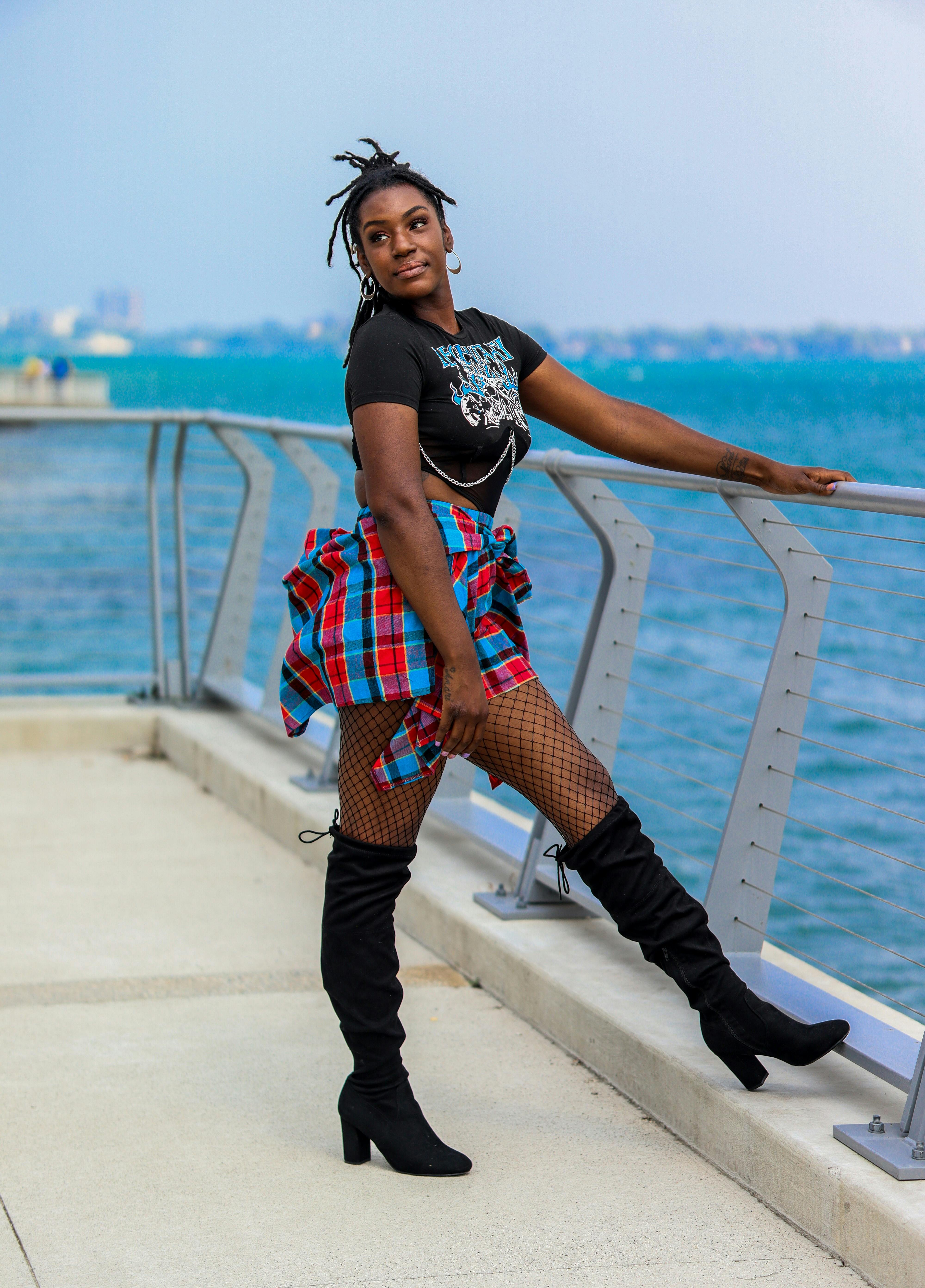 Woman in Boots on a Heel and Fishnets Posing on the Pier · Free Stock Photo