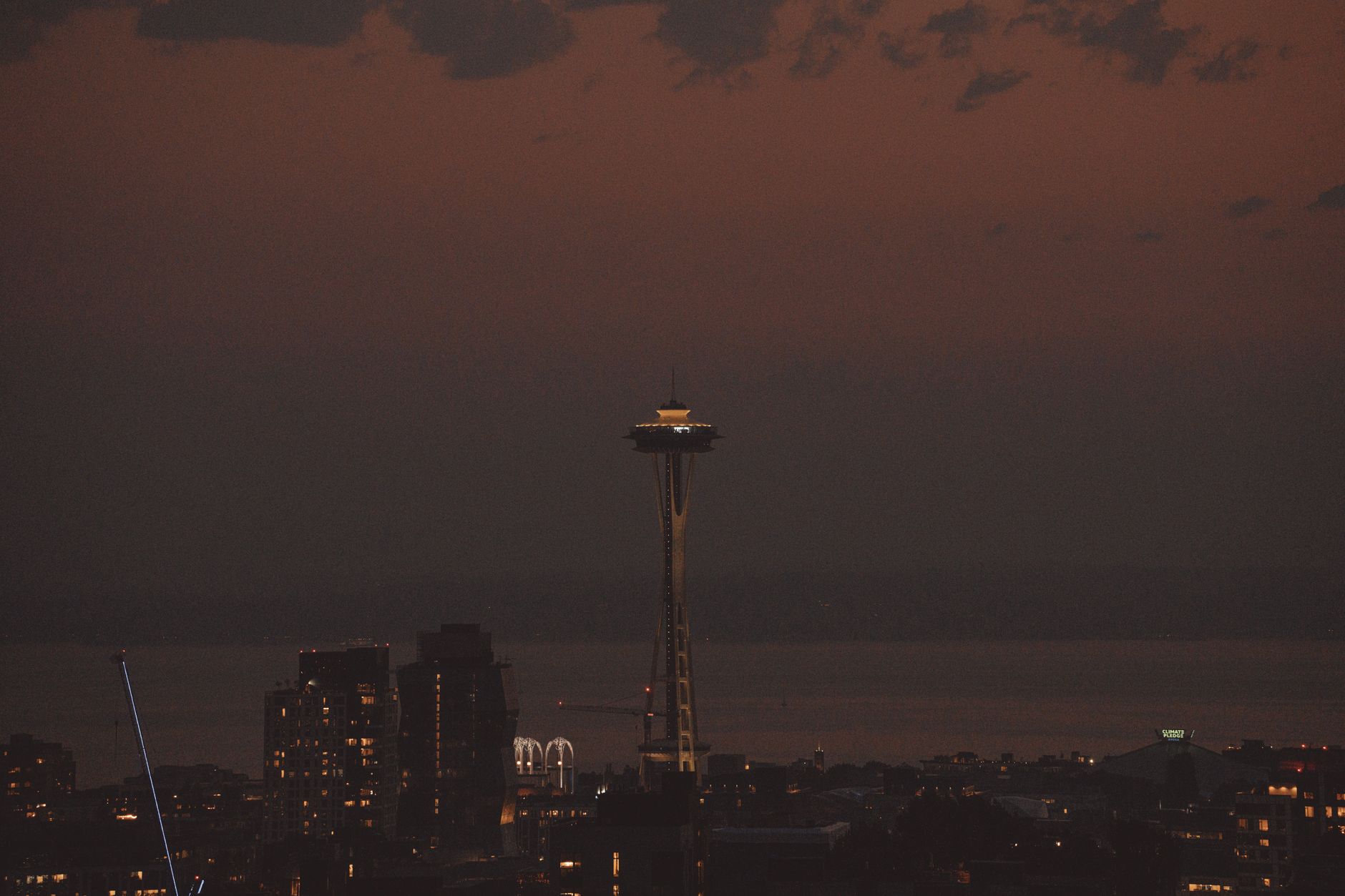 Aerial dusk view of Seattle skyline with the iconic Space Needle and downtown lights.