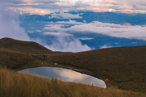 Hikers Camp on the Shore of a Small Mountain Lake Above a Foggy Valley