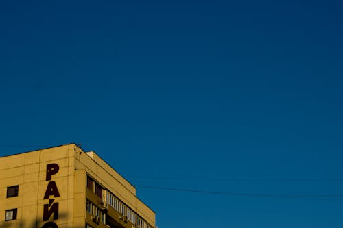 Top Part of a Tall Building under Blue Sky 