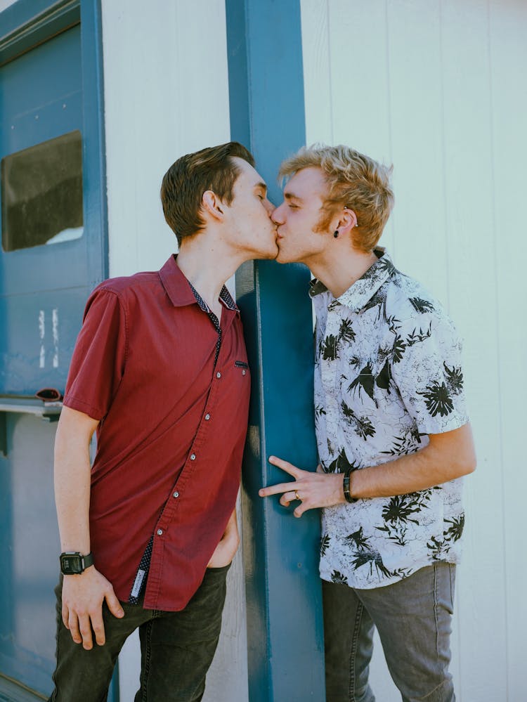 Two Young Men Standing Outside And Kissing 