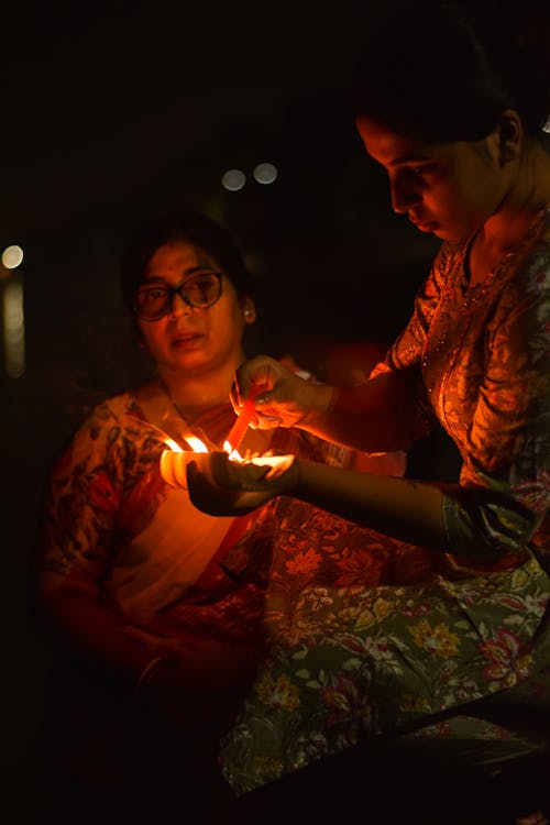 Women in Traditional Clothing Holding Burning Candles 