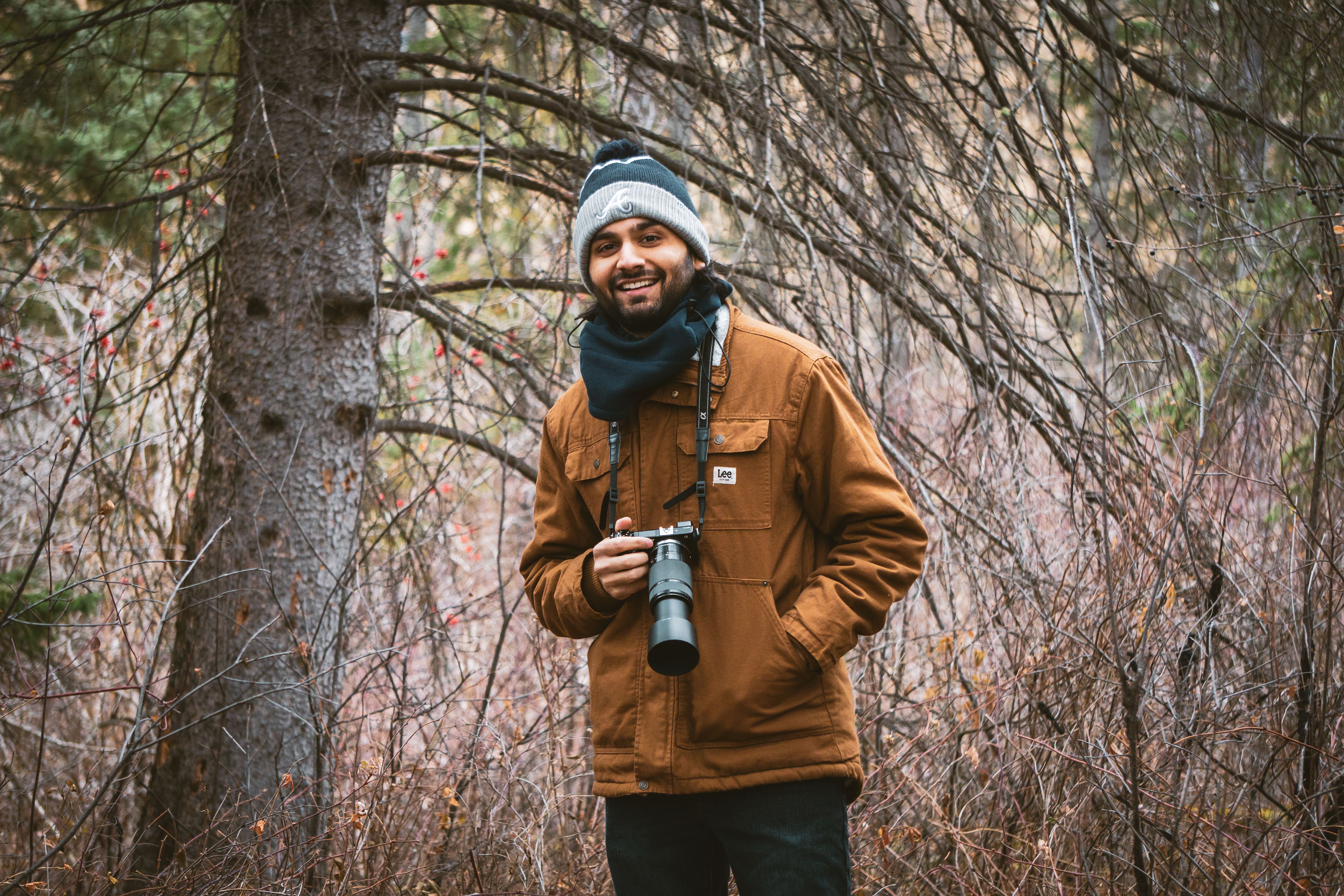 A smiling man with a camera explores the forests of Whitemud Creek, Alberta.