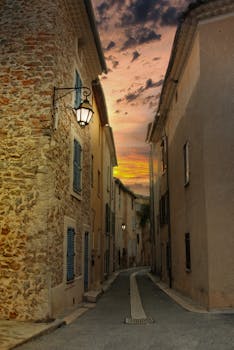 A cozy, narrow alley between historic buildings at sunset, capturing a serene urban atmosphere.