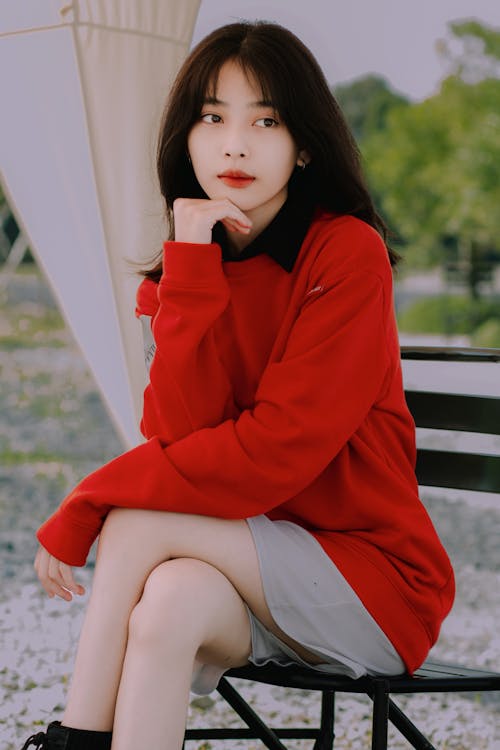 Young Woman in a Red Blouse Sitting Outside 