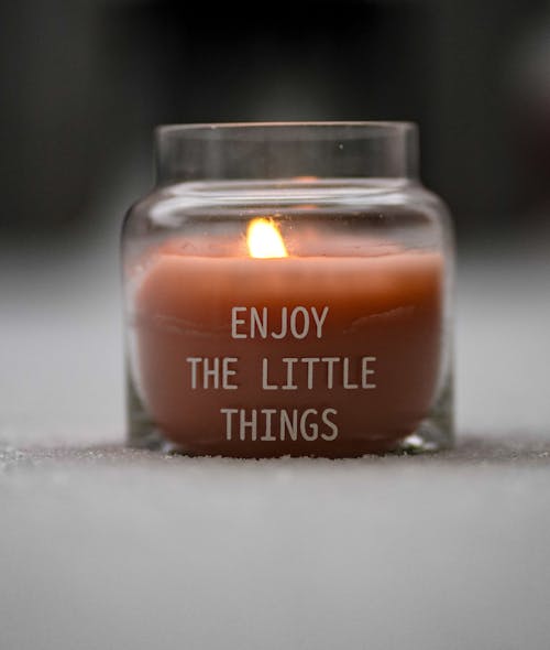 Close-up of a Candle in a Glass with a Quote 