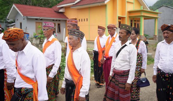 Elders in traditional attire participate in a cultural gathering in Badjo, Indonesia.