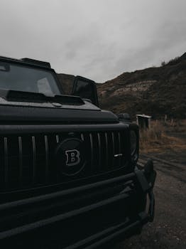 Close-up of a rugged black SUV parked in a remote, mountainous area.