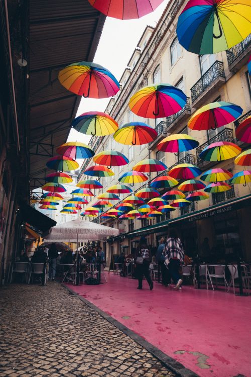 Free Colorful umbrellas decorate a lively urban street, creating a vibrant and artistic scene. Stock Photo