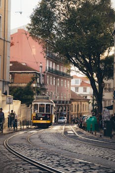 Scenic view of a historic Lisbon street with a classic tram navigating the cobblestone tracks.