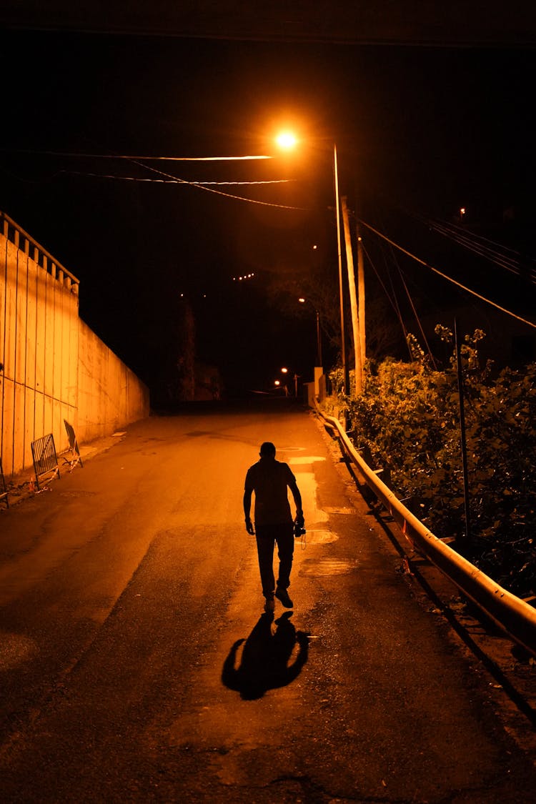 Man Walking On A Street At Night 