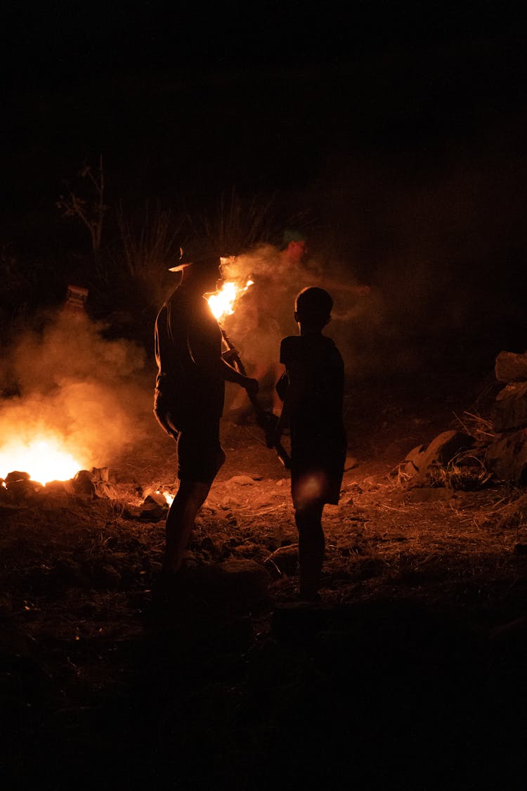 Silhouette Of People In Front Of A Fire 