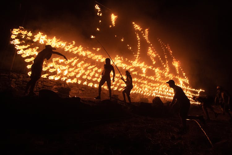 Silhouette Of People In Front Of A Fire 