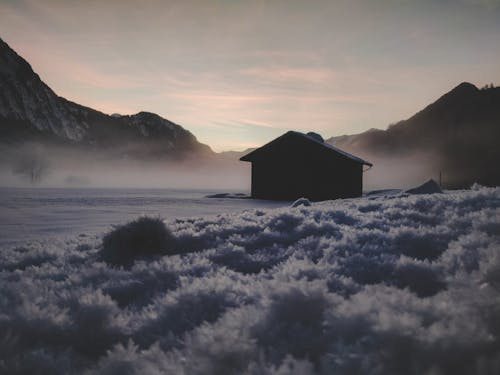 Silhouette of House Near Mountains