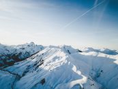在一个晴朗的冬日，一幅冰雪覆盖的山脉壮丽鸟瞰图