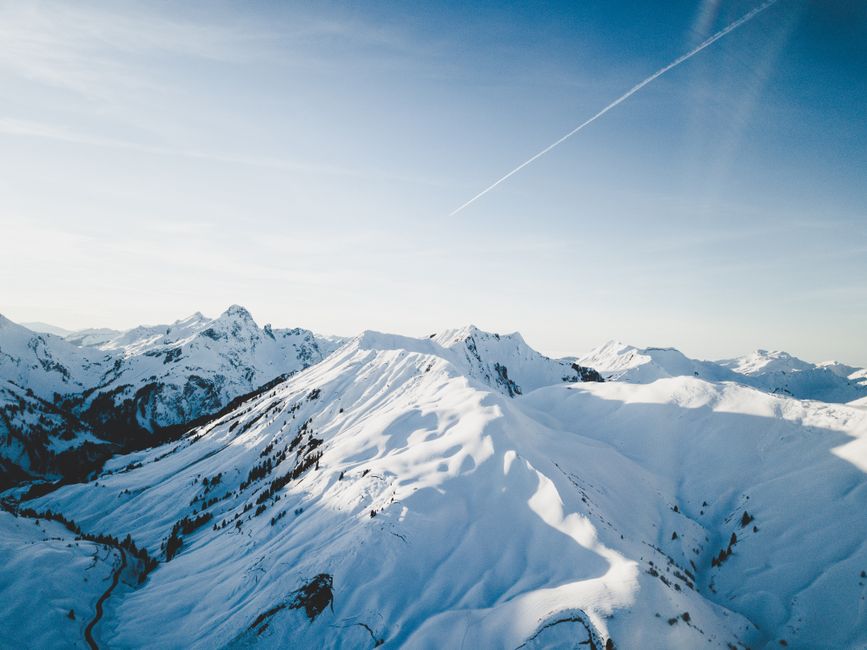 A breathtaking aerial view of a snow-covered mountain range on a clear winter day.