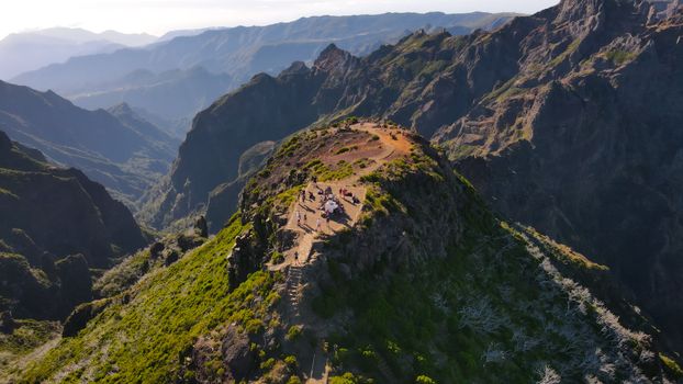 A group of hikers enjoy the stunning view from a mountain peak at sunrise.