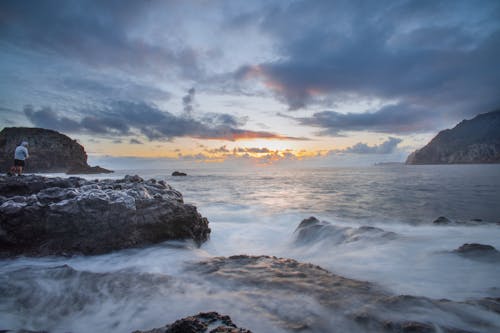 Sunrise Over a Rocky Shore Washed by the Foaming Waters of the Ocean